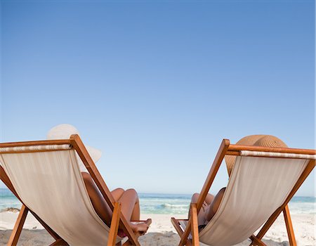 Attractive young women lying on deck chairs on the beach Stock Photo - Premium Royalty-Free, Code: 6109-06004070