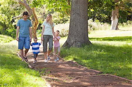 shade - A family moving closer towards the camera in the park Stock Photo - Premium Royalty-Free, Code: 6109-06004013