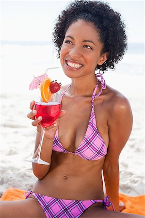 food and sun - Young woman looking up while holding a strawberry cocktail and beaming Stock Photo - Premium Royalty-Free, Code: 6109-06004149