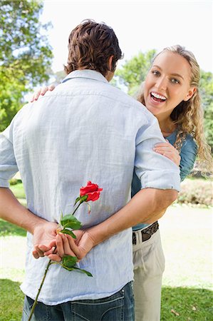 Smiling young woman just had a look behind her boyfriends back Stock Photo - Premium Royalty-Free, Code: 6109-06004341
