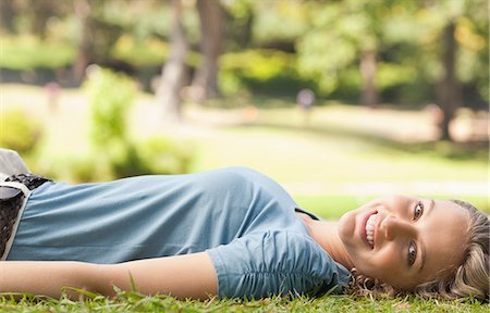 Side view of a young woman lying on the lawn Stock Photo - Premium Royalty-Free, Code: 6109-06004359