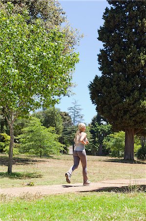 simsearch:6109-06004305,k - Young sportswoman jogging through the park Stock Photo - Premium Royalty-Free, Code: 6109-06004315