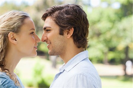 staring - Side view of a happy young couple in the park Stock Photo - Premium Royalty-Free, Code: 6109-06004322