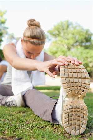 simsearch:6109-06004305,k - Young sportswoman on the grass doing her stretches Stock Photo - Premium Royalty-Free, Code: 6109-06004554