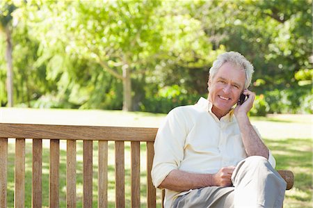 spring cell phone - Smiling man looking to his right side while making a call as he sits on a bench in a park Stock Photo - Premium Royalty-Free, Code: 6109-06004744