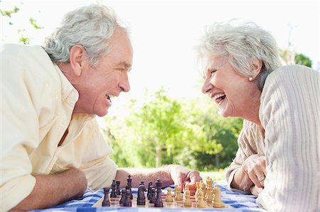 Homme et une femme riant tout en jouant aux échecs dans le parc Photographie de stock - Premium Libres de Droits, Code: 6109-06004787
