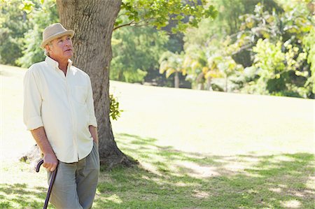 simsearch:6109-06004701,k - Man leaning on a cane while looking upwards in a park Stock Photo - Premium Royalty-Free, Code: 6109-06004700