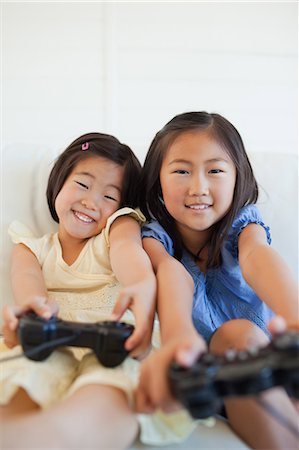 A close up shot of two sisters playing a game with  their hands stretched out Stock Photo - Premium Royalty-Free, Code: 6109-06004854