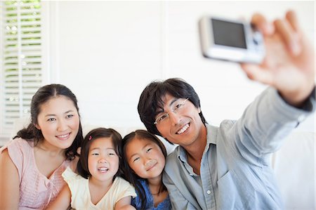 Family on the couch posing for a family photo Stock Photo - Premium Royalty-Free, Code: 6109-06004871