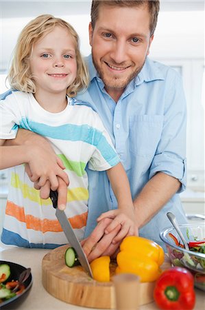 A happy smiling boy and his dad about to cut some vegetables in the kitchen Stock Photo - Premium Royalty-Free, Code: 6109-06005146