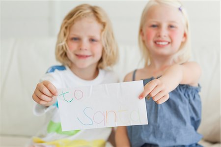 A letter addressed to Santa being held by a brother and sister. Stock Photo - Premium Royalty-Free, Code: 6109-06005123