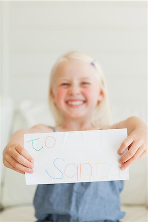 stand sofa - Focus on a letter to Santa being held out by a little girl Stock Photo - Premium Royalty-Free, Code: 6109-06005121