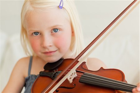 Une jeune fille regardant tout droit devant elle, car elle joue du violon Photographie de stock - Premium Libres de Droits, Code: 6109-06005239