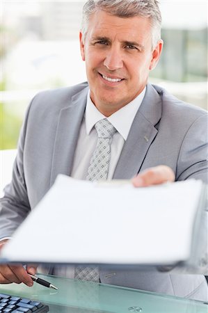 documento - Portrait of a boss giving a file in a bright office Foto de stock - Sin royalties Premium, Código: 6109-06005345