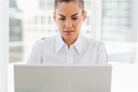 simsearch:6109-06005472,k - Krauses kurzhaarige Frau arbeitet mit einem Laptop in einem hellen Büro Stockbilder - Premium RF Lizenzfrei, Bildnummer: 6109-06005352
