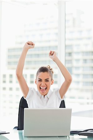 female computer laughing - Very happy tanned businesswoman raising their arms in a bright office Stock Photo - Premium Royalty-Free, Code: 6109-06005396