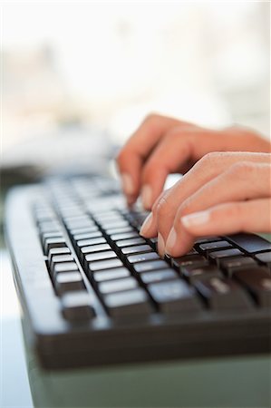 Close-up of a woman hands typing on a keyboard in a bright office Fotografie stock - Premium Royalty-Free, Codice: 6109-06005456