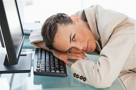 person being lazy on computer - Portrait of a businesswoman head on the keyboard in a bright office Stock Photo - Premium Royalty-Free, Code: 6109-06005477