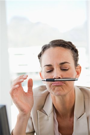 raised - Businesswoman playing with her pen in a bright office Stock Photo - Premium Royalty-Free, Code: 6109-06005496