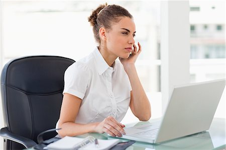 phone young woman computer - Tanned businesswoman frowning while phoning in a bright office Stock Photo - Premium Royalty-Free, Code: 6109-06005403