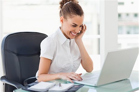 Tanned businesswoman smiling while phoning in a bright office Foto de stock - Royalty Free Premium, Número: 6109-06005400
