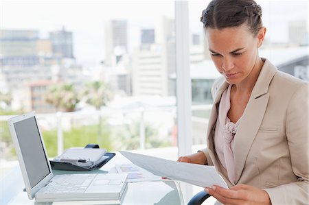 simsearch:6109-06005455,k - Businesswoman reading files in a bright office Fotografie stock - Premium Royalty-Free, Codice: 6109-06005435