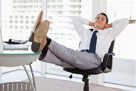 Portrait d'un pieds d'homme d'affaires sur son bureau dans un bureau lumineux Photographie de stock - Premium Libres de Droits, Code: 6109-06005564