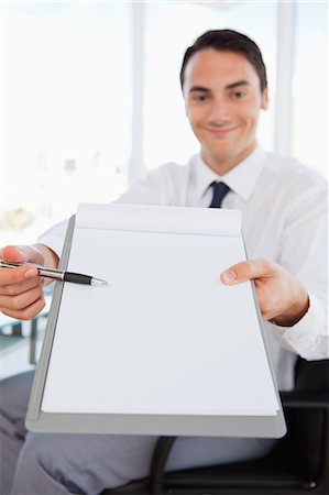 simsearch:6109-06005455,k - Smiling businessman showing a file in a bright office Fotografie stock - Premium Royalty-Free, Codice: 6109-06005569