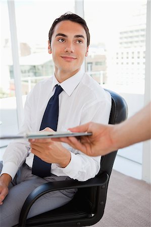 simsearch:6109-06005455,k - Handsome businessman showing a file in a bright office Fotografie stock - Premium Royalty-Free, Codice: 6109-06005571