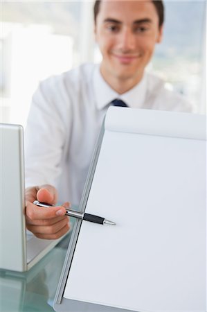 simsearch:6109-06005455,k - Portrait of a businessman showing a file in a bright office Fotografie stock - Premium Royalty-Free, Codice: 6109-06005575