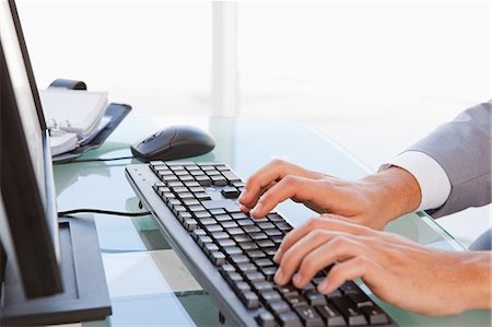 Gros plan d'un homme d'affaires tapant sur son clavier dans un bureau lumineux Photographie de stock - Premium Libres de Droits, Code: 6109-06005528