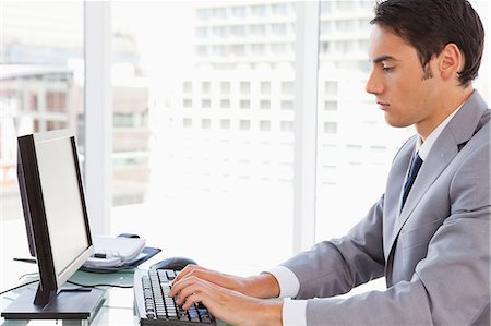 Homme d'affaires tapant sur son clavier dans un bureau lumineux Photographie de stock - Premium Libres de Droits, Code: 6109-06005529