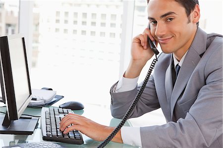 simsearch:6109-06005536,k - Porträt eines Kaufmanns am Telefon an seinem Schreibtisch in einem hellen Büro Stockbilder - Premium RF Lizenzfrei, Bildnummer: 6109-06005533