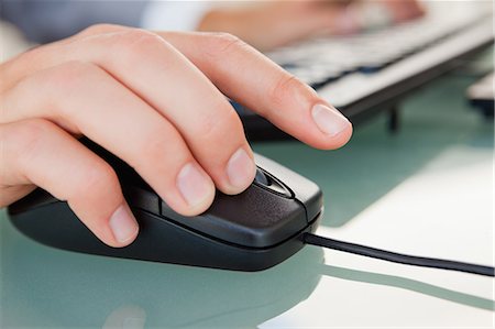 Close-up of man hand clicking with a mouse on a glass desk Stock Photo - Premium Royalty-Free, Code: 6109-06005537