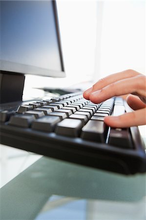 Gros plan des mains d'homme tapant sur un clavier dans un bureau lumineux Photographie de stock - Premium Libres de Droits, Code: 6109-06005535