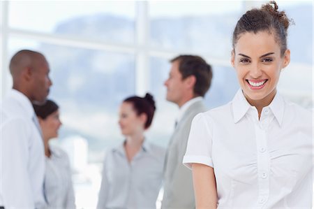 female cross arms confident smile - Smiling young tradeswoman with colleagues behind her Stock Photo - Premium Royalty-Free, Code: 6109-06005750