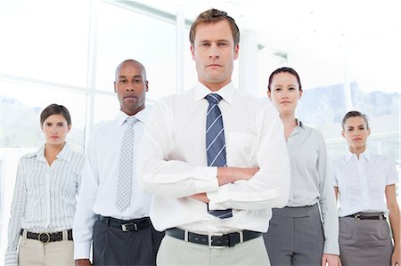 simsearch:6109-06005688,k - Confident looking businessman with his arms crossed together with his team Foto de stock - Royalty Free Premium, Número: 6109-06005784