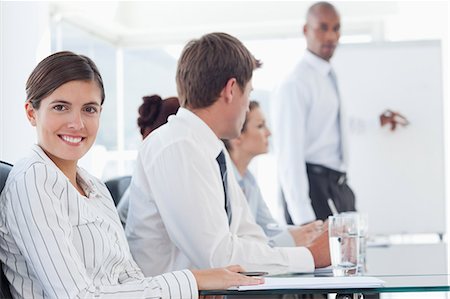 simsearch:6109-06005809,k - Smiling young saleswoman with presentation behind held behind her Stock Photo - Premium Royalty-Free, Code: 6109-06005854