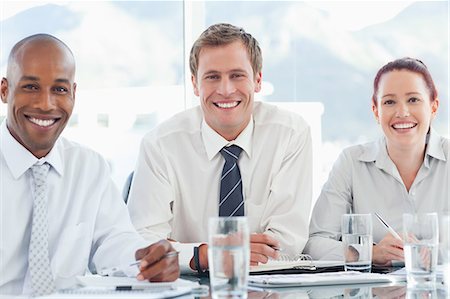 simsearch:6109-06005806,k - Smiling young businesspeople sitting together at a table Stock Photo - Premium Royalty-Free, Code: 6109-06005863