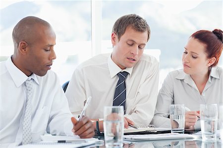 Young businesspeople sitting at a table while having a conversation Stock Photo - Premium Royalty-Free, Code: 6109-06005864