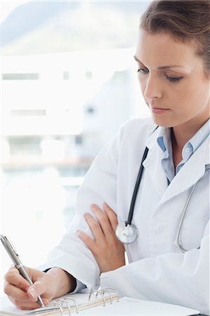 simsearch:6109-06005901,k - Female doctor taking notes Fotografie stock - Premium Royalty-Free, Codice: 6109-06005866