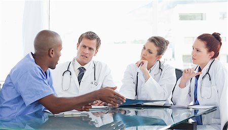 pflegekraft - Eine Krankenschwester spricht mit den drei Ärzten in einem Büro. Stockbilder - Premium RF Lizenzfrei, Bildnummer: 6109-06005870
