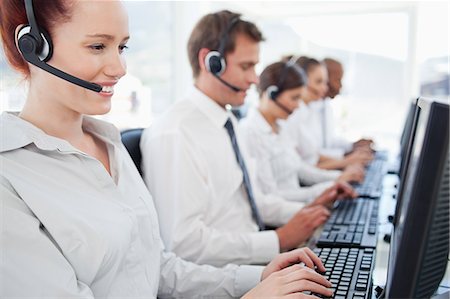 simsearch:6109-06005806,k - Young call center agents sitting in a line at work Stock Photo - Premium Royalty-Free, Code: 6109-06005814