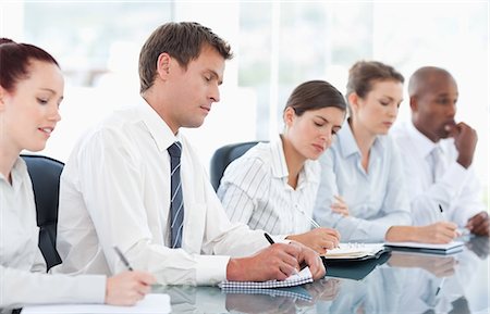 simsearch:6109-06005809,k - Young businesspeople taking notes during a meeting Stock Photo - Premium Royalty-Free, Code: 6109-06005824