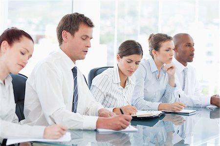 Young salespeople taking notes during a meeting Stock Photo - Premium Royalty-Free, Code: 6109-06005826