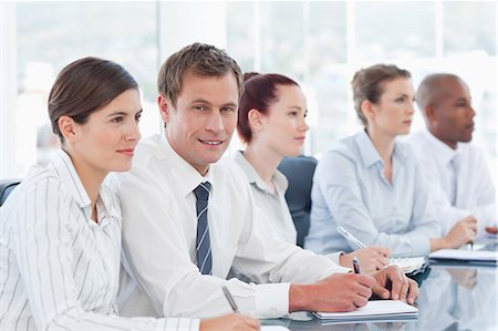 smiling corporate man woman - Young salesteam sitting in a meeting Stock Photo - Premium Royalty-Free, Code: 6109-06005829