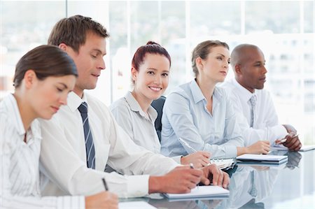 simsearch:6109-06005809,k - Smiling young saleswoman sitting in a meeting with her colleagues Stock Photo - Premium Royalty-Free, Code: 6109-06005830