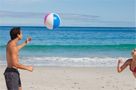 simsearch:6109-06195645,k - Lovers in swimsuit playing with a ball on the beach Foto de stock - Sin royalties Premium, Código: 6109-06005958