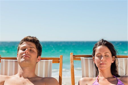 simsearch:6109-06006157,k - Close-up on a couple taking a sunbath with the ocean in background Stock Photo - Premium Royalty-Free, Code: 6109-06006142