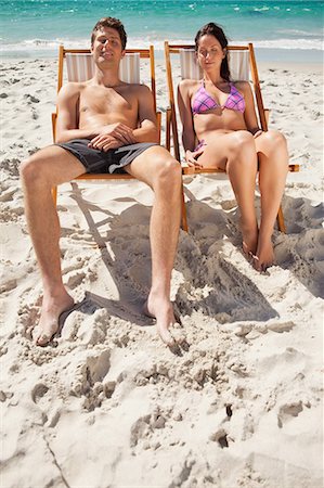 silla de playa - Lovers taking a sunbath on the beach with the ocean in bakground Foto de stock - Sin royalties Premium, Código: 6109-06006145